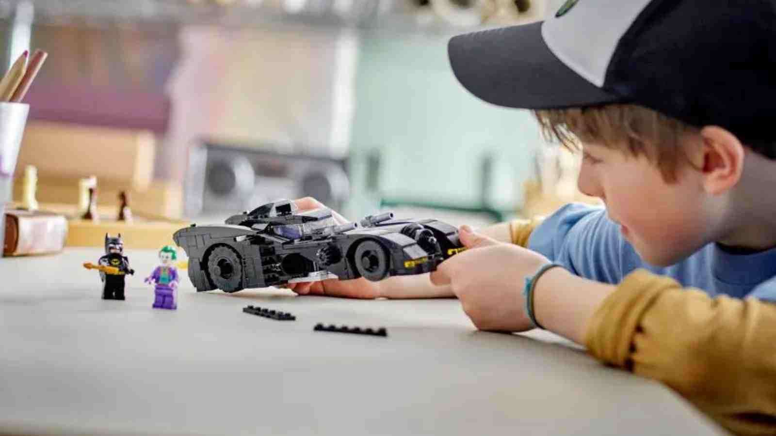 A child with their LEGO Batman Batmobile: Batman vs. The Joker Chase set
