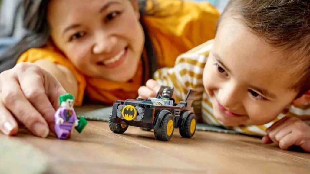 An adult and child with the LEGO Batman Batmobile Pursuit: Batman vs. The Joker set