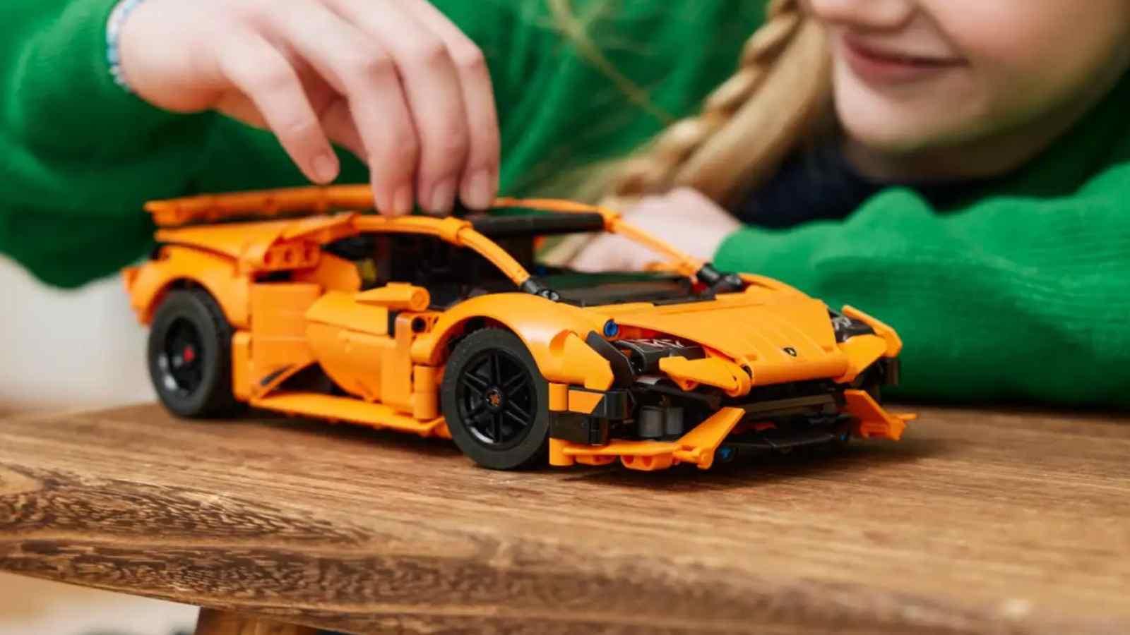 A child playing with the LEGO Technic Lamborghini Huracán Orange 