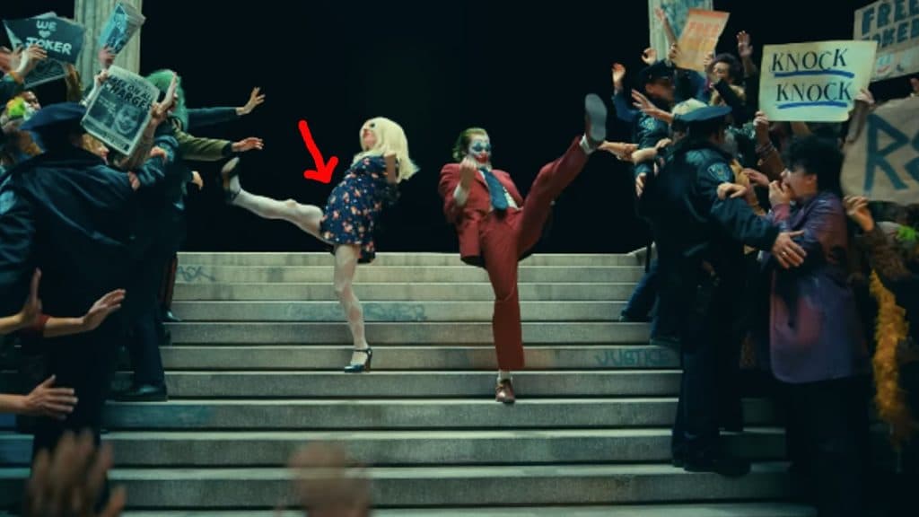 Harley Quinn and Joker kick their legs up on a staircase