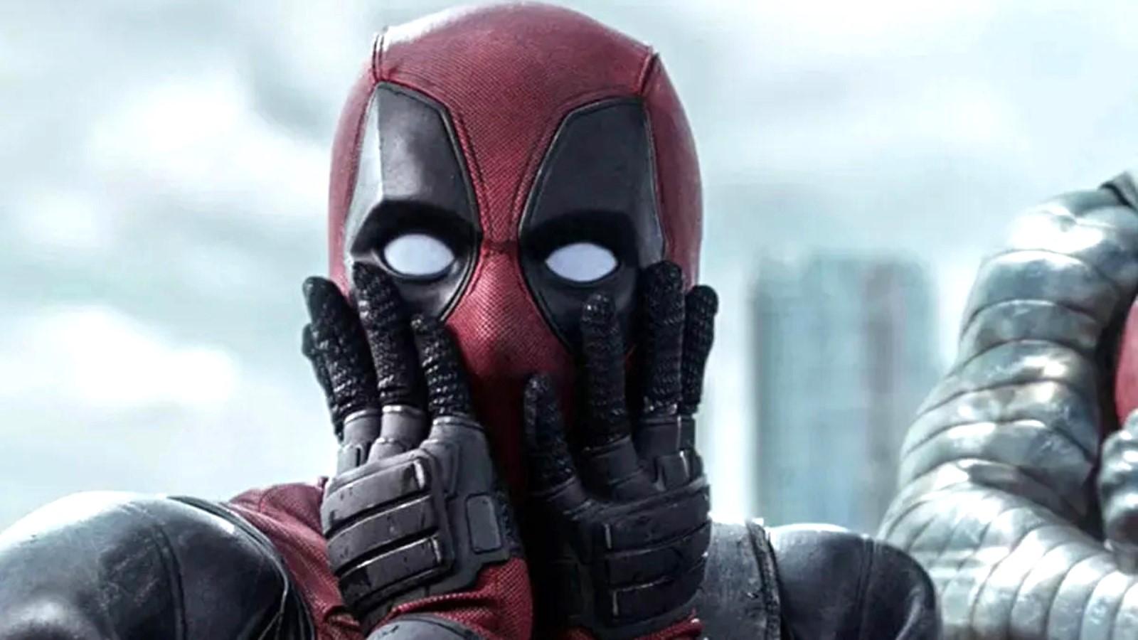 Ryan Reynolds as Deadpool, pressing his hands against his face
