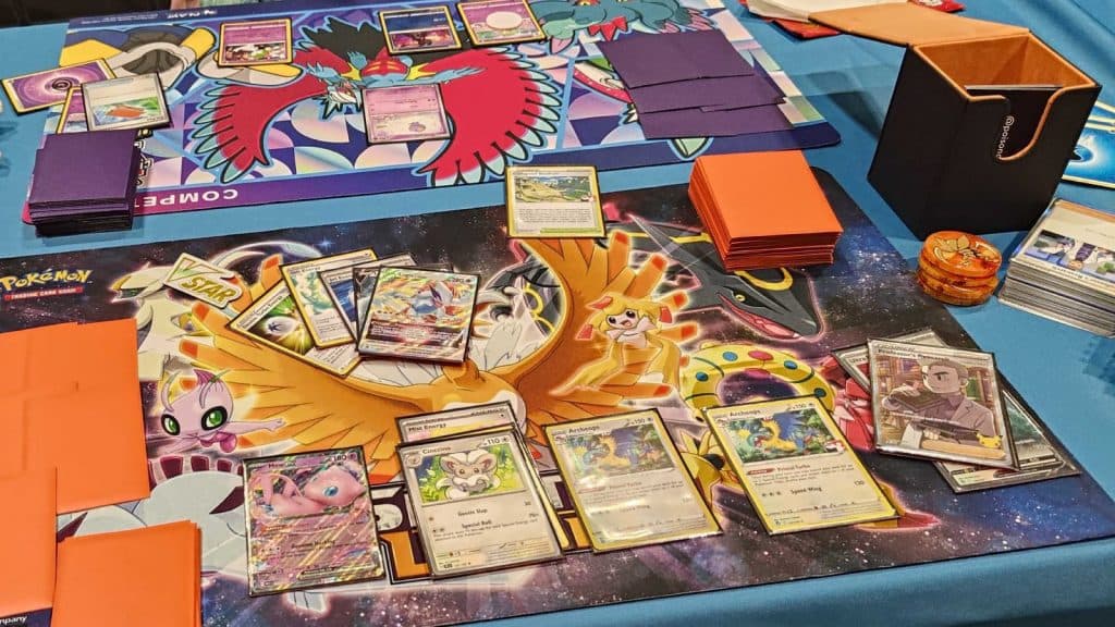 A game of Pokemon TCG is being played on a large table
