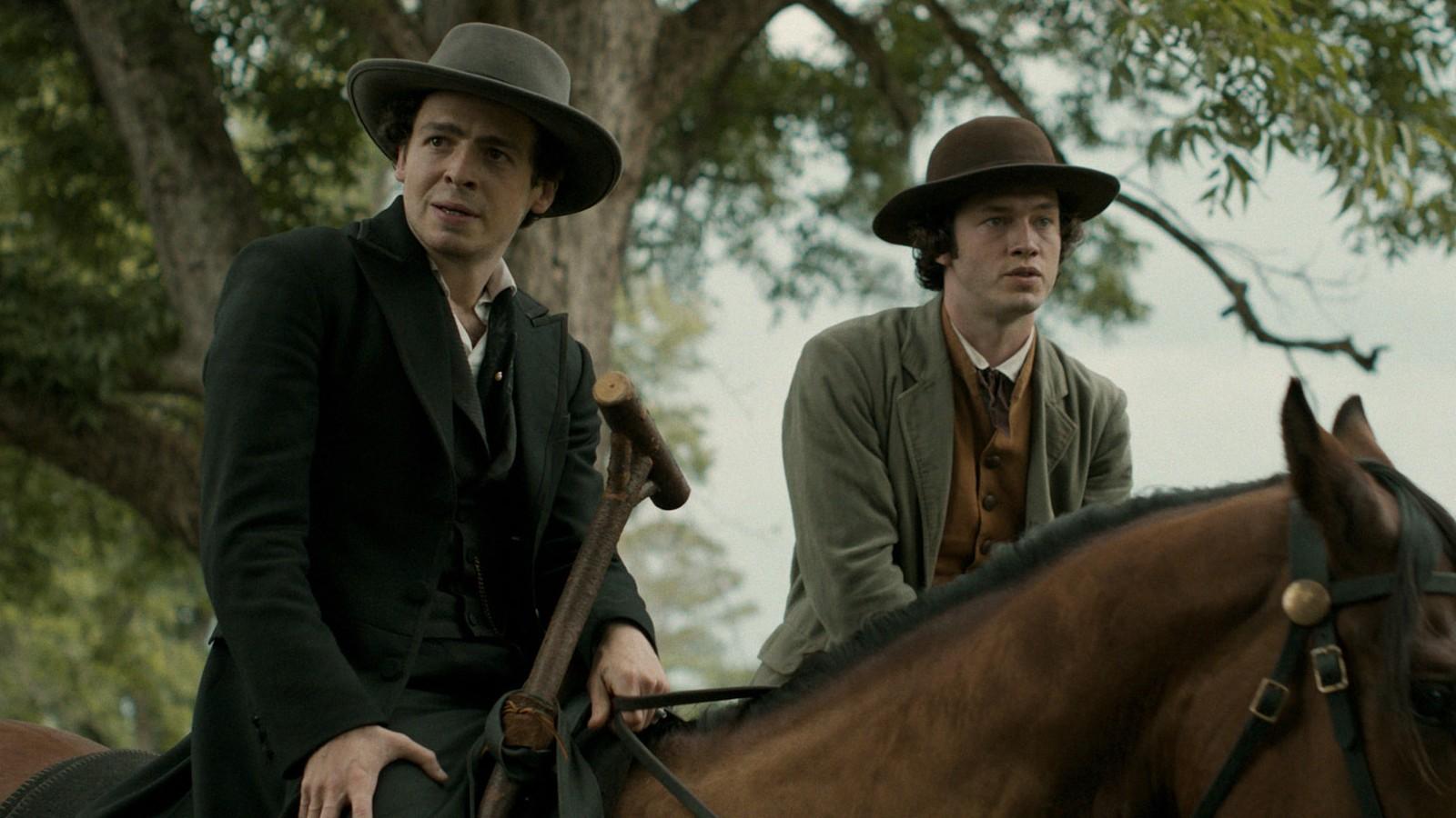 Anthony Boyle - on the left and playing John Wilkes Booth - riding a horse in Manhunt.