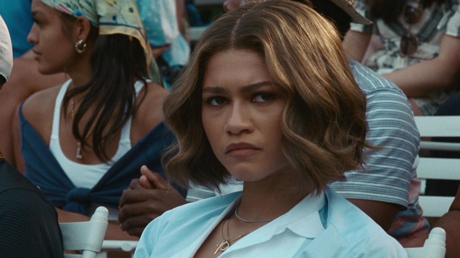 Zendaya as Tashi in Challengers, sitting in the stands and looking concerned