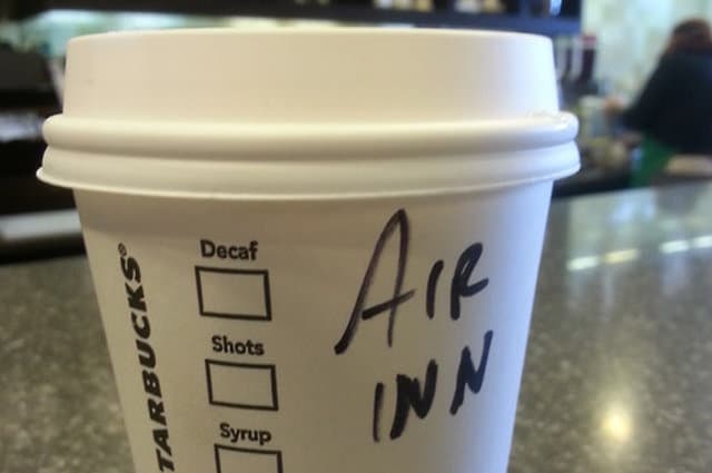 A starbucks cup that says, "Air Inn"