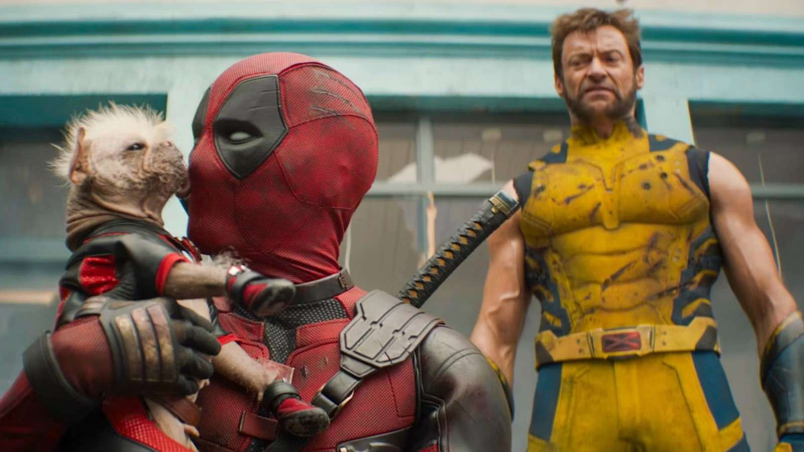 Ryan Reynolds and Hugh Jackman as Deadpool and Wolverine with Deadpool holding a dog that's licking his face