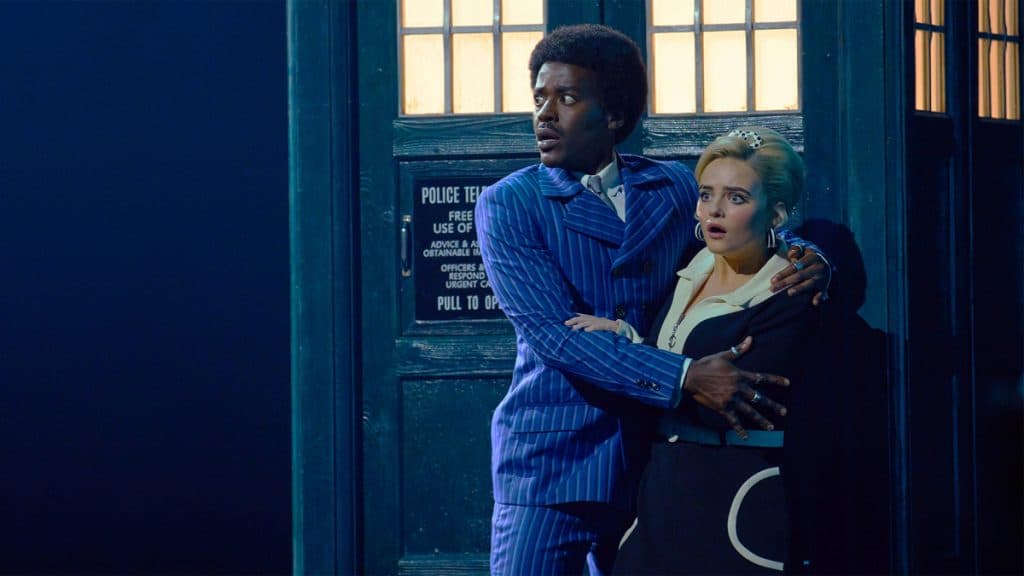 The Doctor and Ruby Sunday stand against the TARDIS holding each other in The Devil's Chord