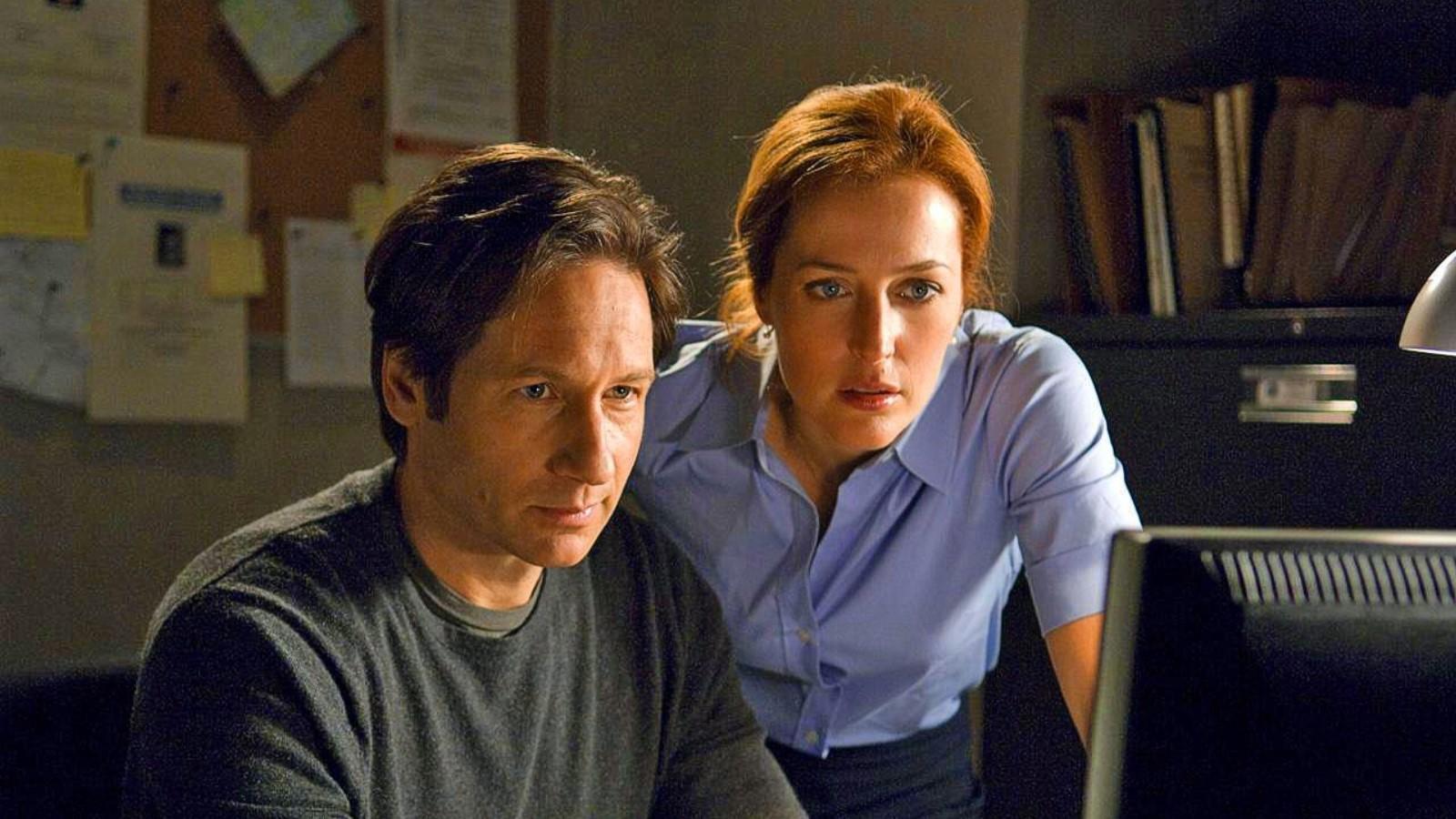 David Duchovny and Gillian Anderson as Fox and Scully in X-Files, looking at a computer