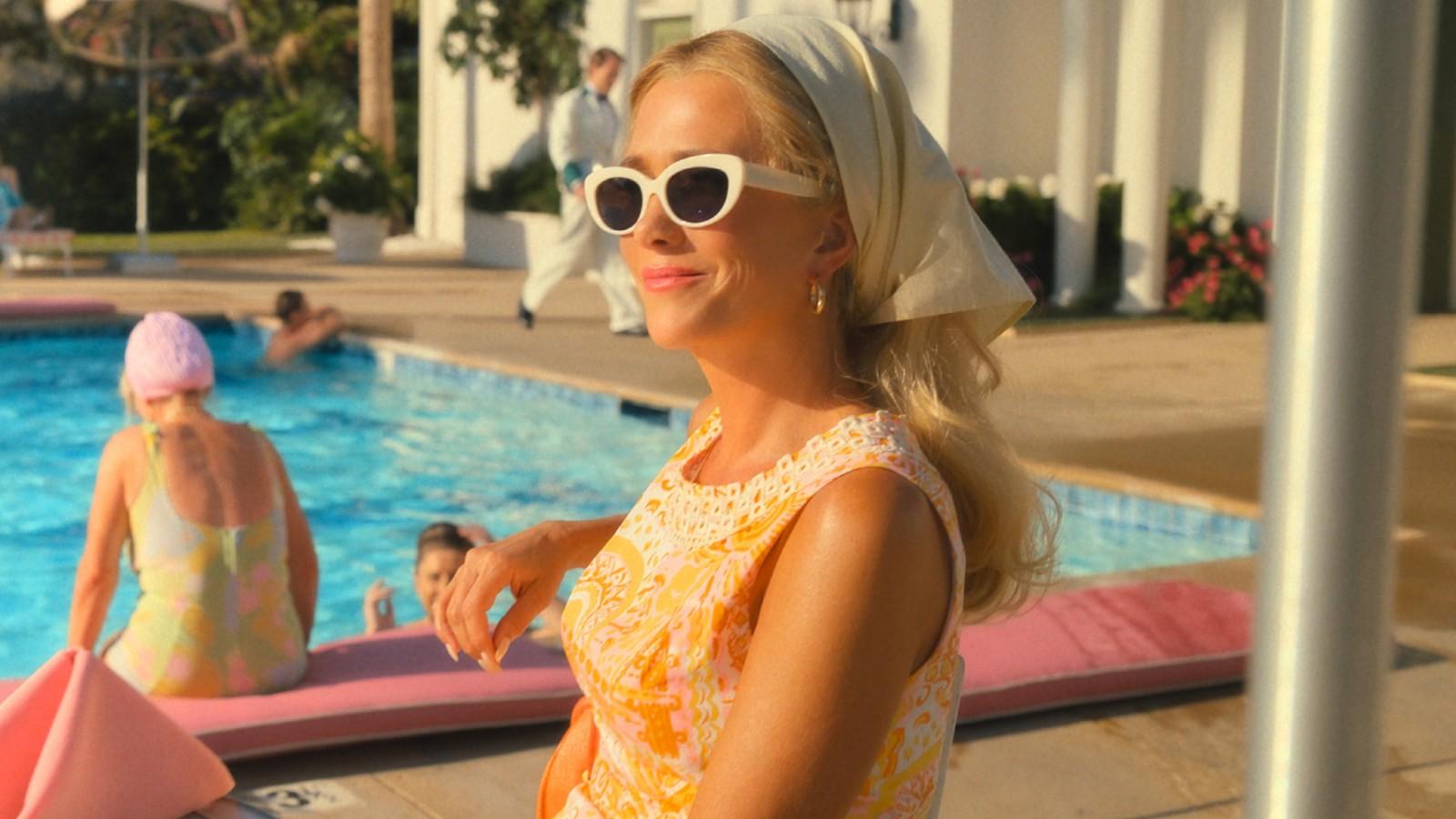 Kristen Wiig sitting by a pool in Palm Royale.