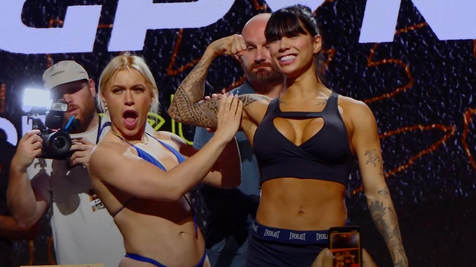Elle Brooke squeezes Jully Poca's bicep at a weigh-in