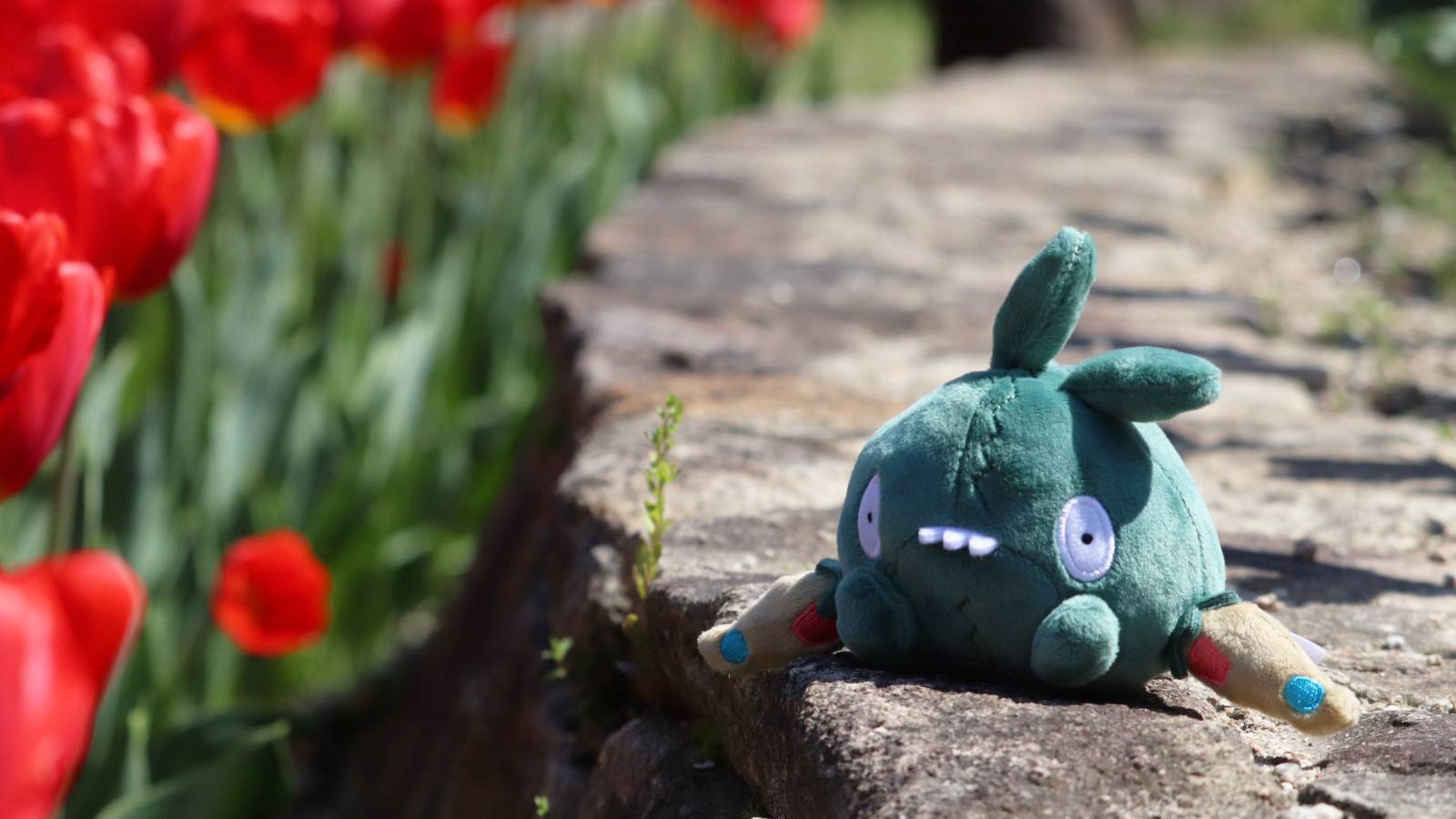 A photography shows a Trubbish plush sat outdoors