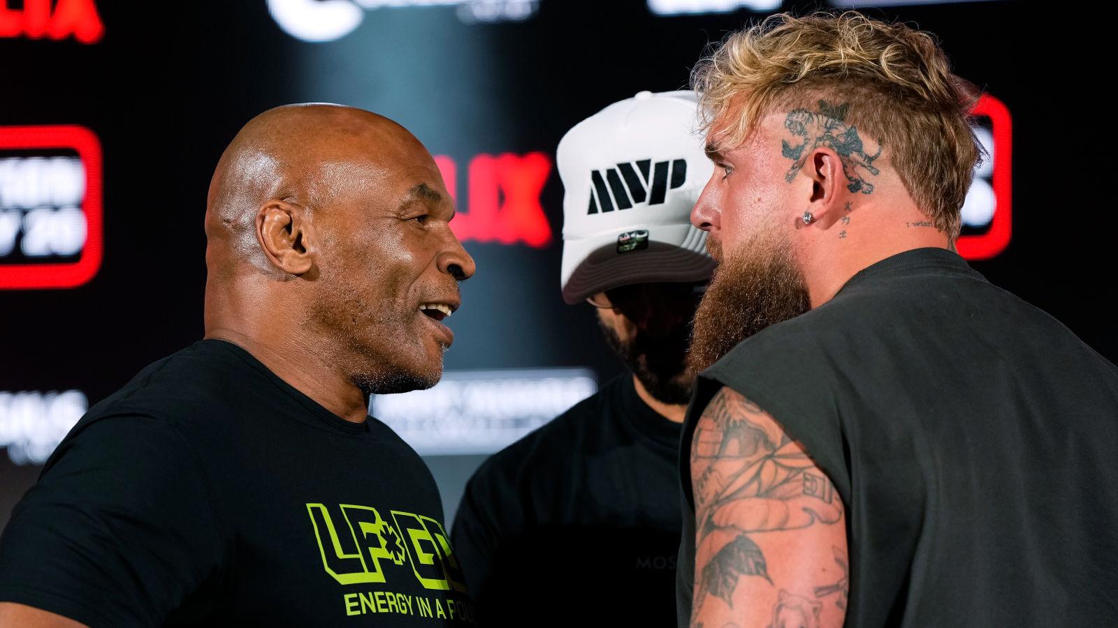 Mike Tyson (L) and Jake Paul (R) look at one another